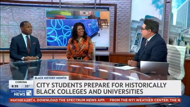 Three news anchors sit at a studio desk discussing Black History Month, with a headline about city students preparing for historically Black colleges and universities displayed on screen.