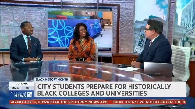 Three news anchors sit at a studio desk discussing Black History Month, with a headline about city students preparing for historically Black colleges and universities displayed on screen.