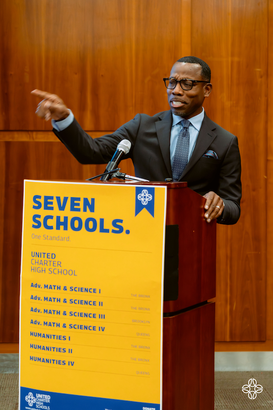 Dr. Curtis Palmore speaks from behind a podium at the United Charter High Schools art showcase.