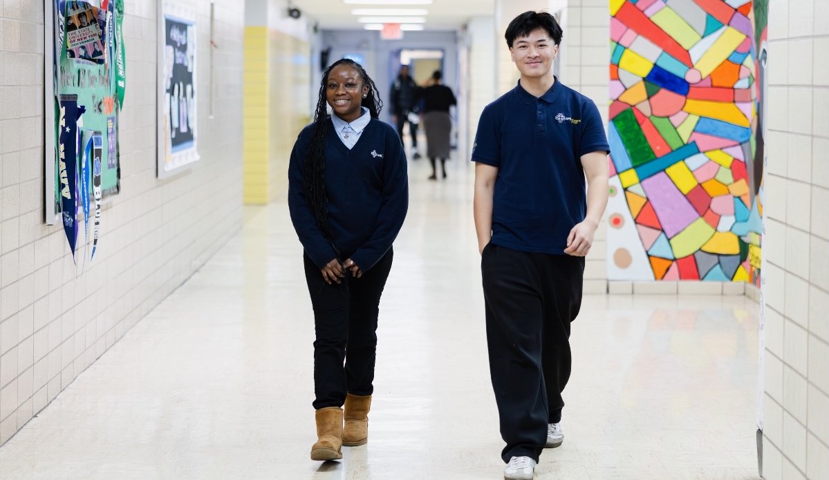 Two students at UCHS AMS in the Bronx walk through a school hallway